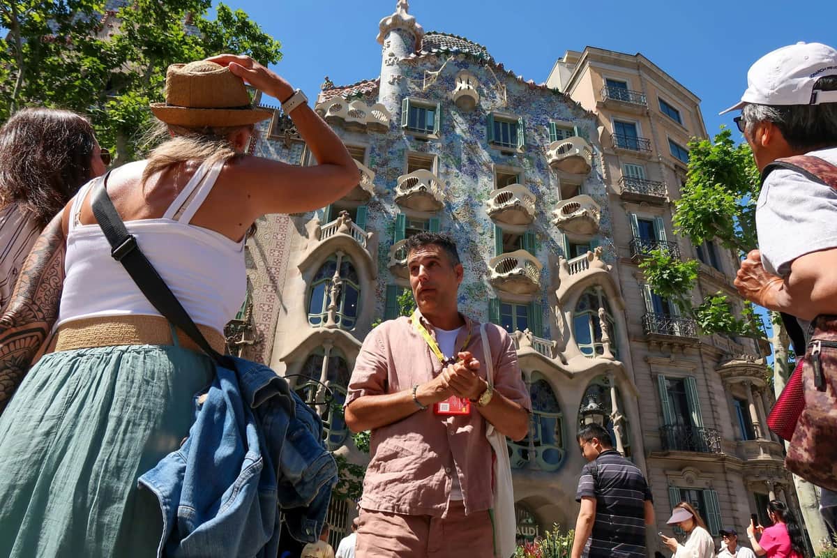 Sagrada Familia, Park Güell & Casa Milà: Guided Tour + Private Transfer A local guide introduces guests to the colorful facade of Casa Batllo, Antoni Gaudi's iconic masterpiece.